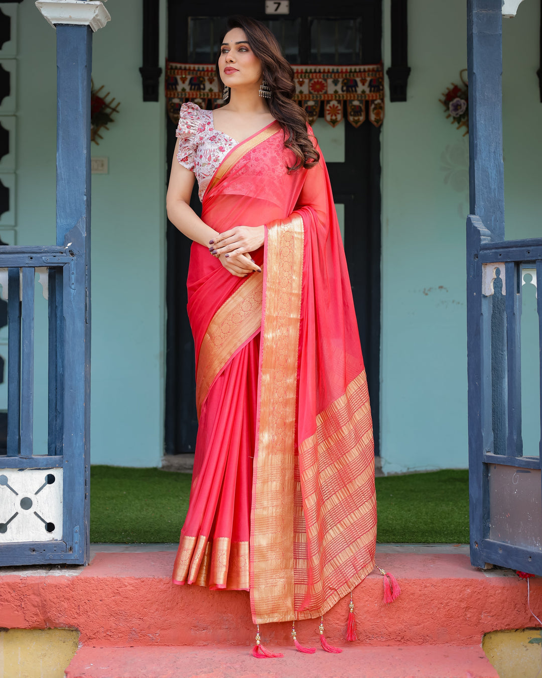 Vibrant Coral Pink Plain Chiffon Saree with Gold Zari Border Floral Ruffled Blouse & Tassel Detailing CHIFFON H 128-132