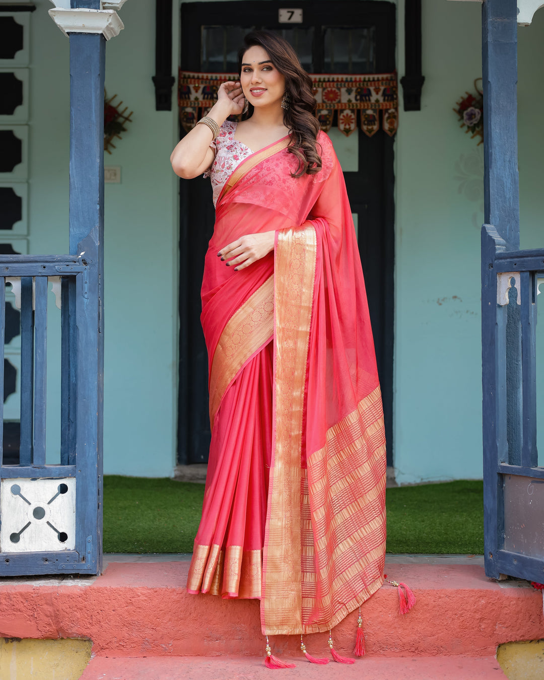Vibrant Coral Pink Plain Chiffon Saree with Gold Zari Border Floral Ruffled Blouse & Tassel Detailing CHIFFON H 128-132