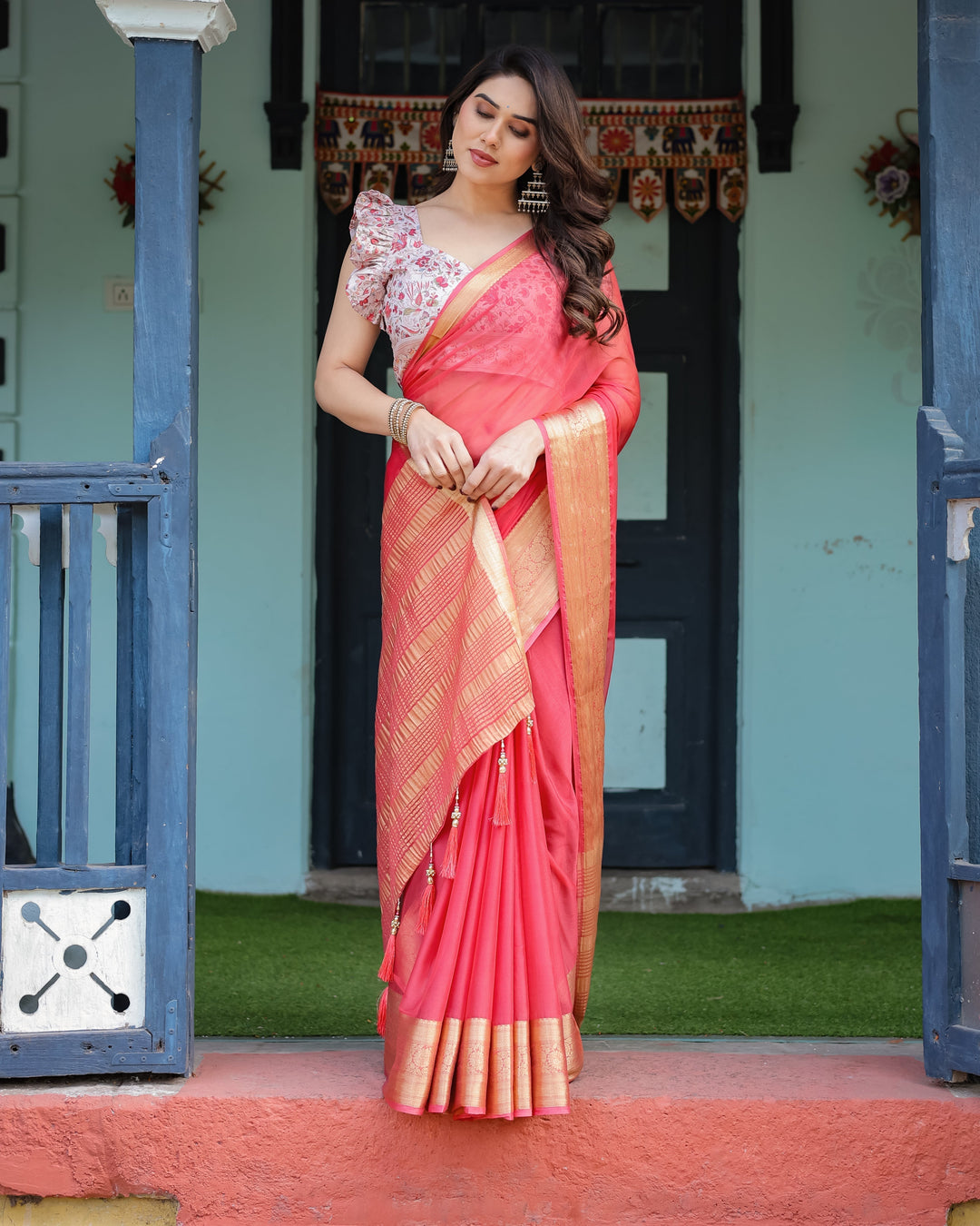 Vibrant Coral Pink Plain Chiffon Saree with Gold Zari Border Floral Ruffled Blouse & Tassel Detailing CHIFFON H 128-132