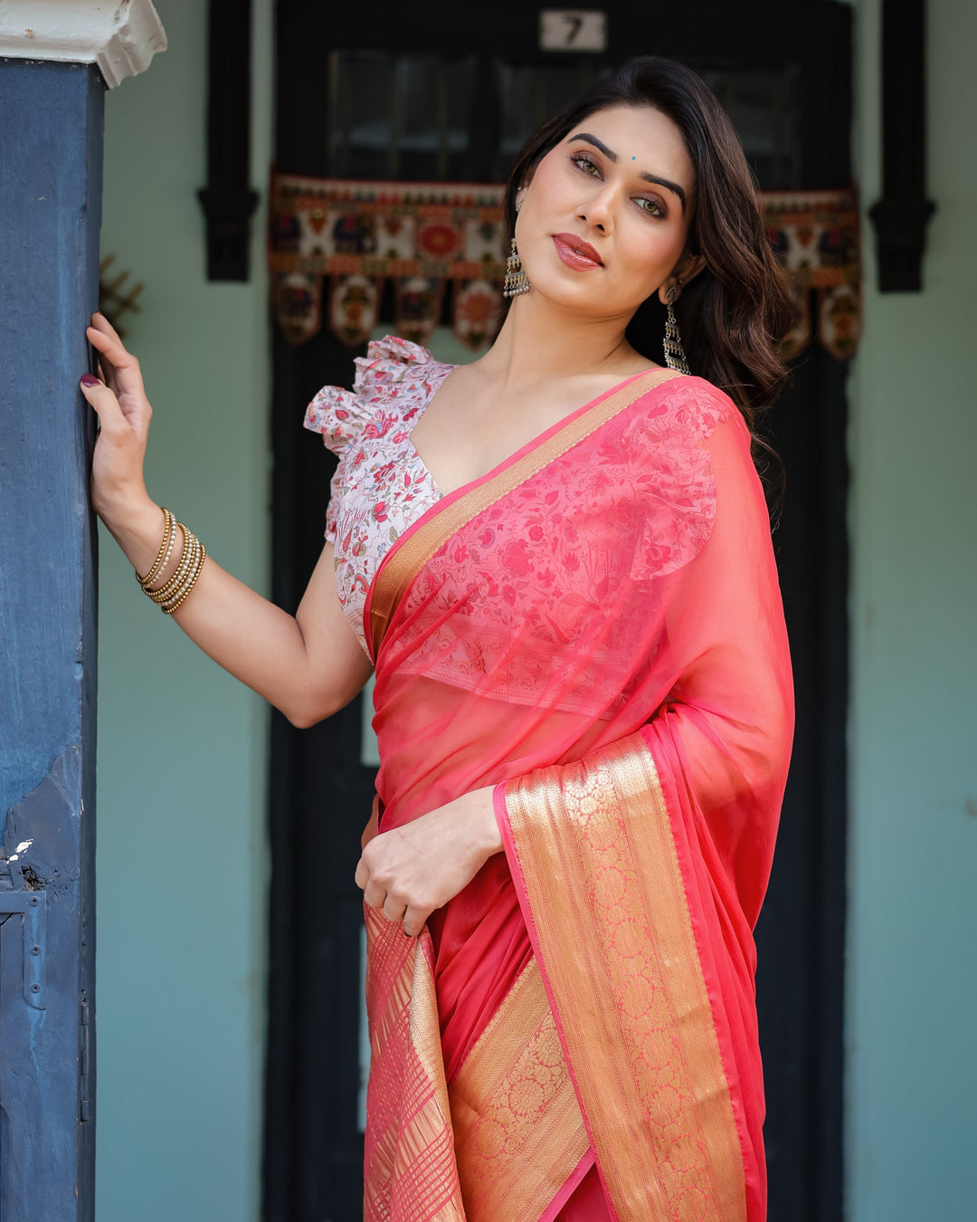 Vibrant Coral Pink Plain Chiffon Saree with Gold Zari Border Floral Ruffled Blouse & Tassel Detailing CHIFFON H 128-132